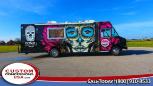 side view of a black food truck with graphic of a day of the dead face