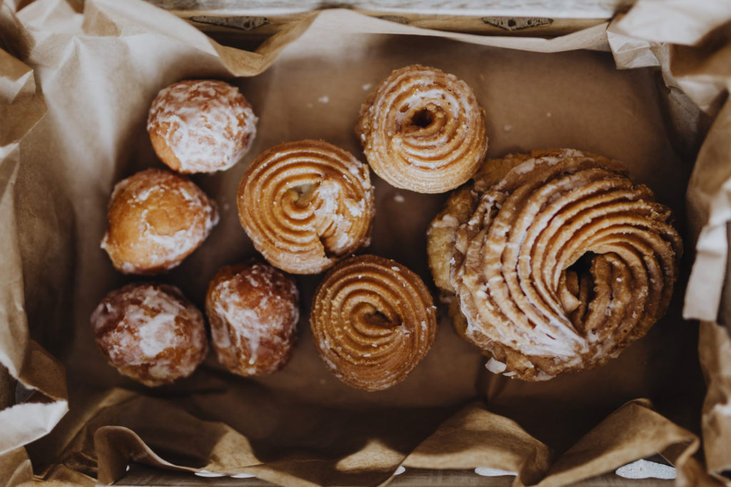 top down view of assorted pastries on a tray lined with brown paper