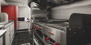 photo of a food truck interior with grill, griddle, ovens, proofing cabinet and sink