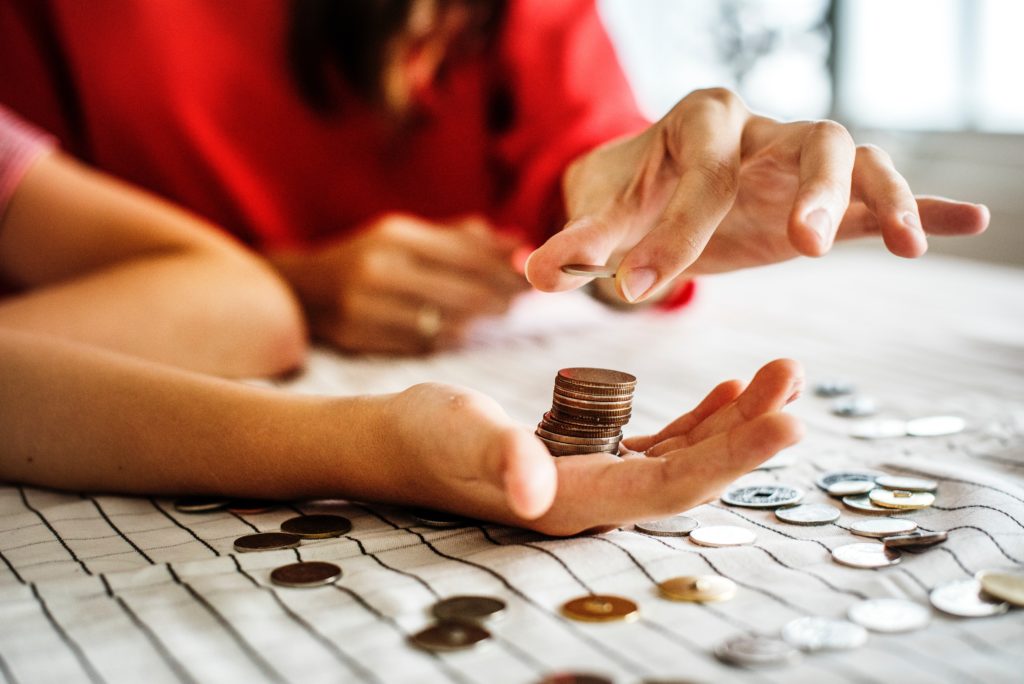 close up photo of adult and child's hands counting coins