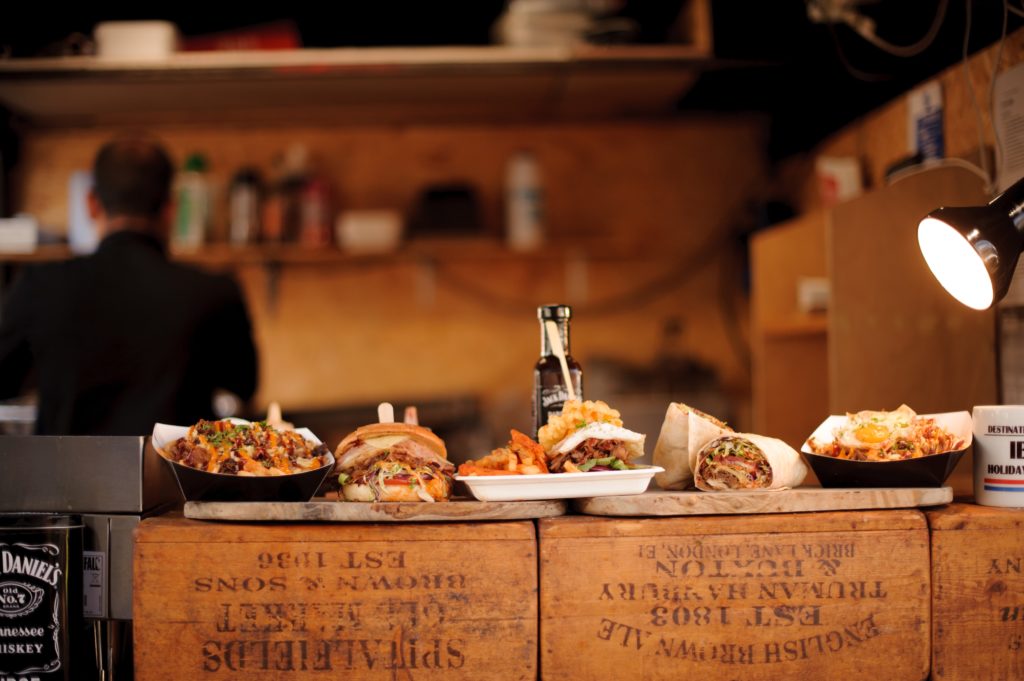 photo of wooden serving boards full of pub-style food on the counter in a rustic restaurant