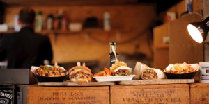 photo of wooden serving boards full of pub-style food on the counter in a rustic restaurant