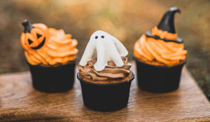 color photo of three halloween cupcakes on a wooden cutting board