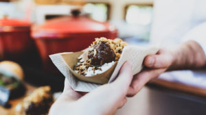 Close-up of a hand picking up meatballs from a food truck