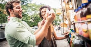 two people buying food from a food truck in the city