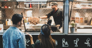 man and woman buying food from a food truck