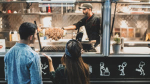 man and woman buying food from a food truck