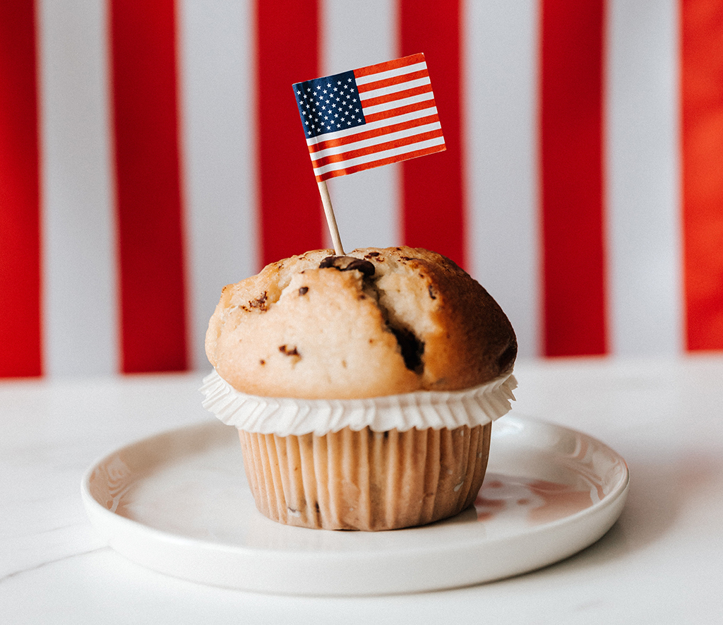 muffin on a plate with an American flag toothpick
