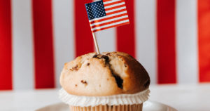 muffin on a plate with an American flag toothpick