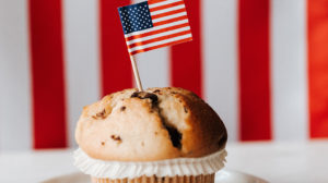 muffin on a plate with an American flag toothpick