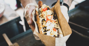 food truck vendor holding a hot dog