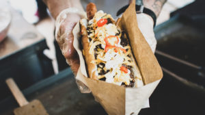 food truck vendor holding a hot dog