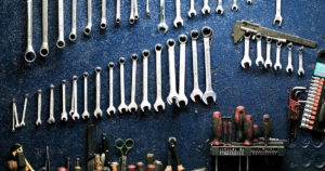 wrenches and other tools hanging on a work bench