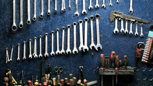 wrenches and other tools hanging on a work bench