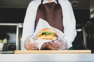 food truck worker holding a burger