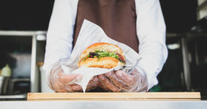 food truck worker holding a burger