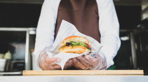 food truck worker holding a burger